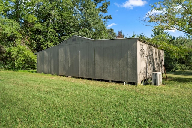 view of outbuilding featuring a yard and central air condition unit