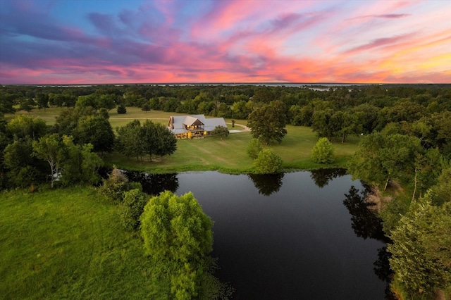 aerial view at dusk featuring a water view