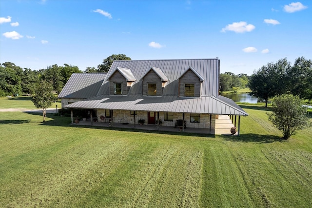 rear view of house featuring a porch, a water view, and a yard