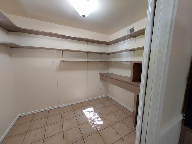 walk in closet with light tile patterned flooring