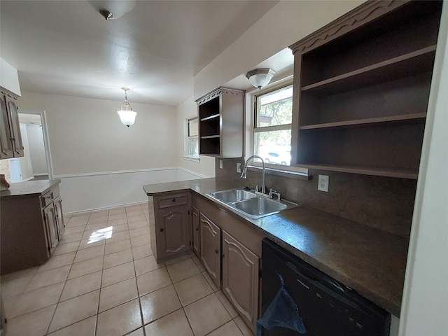 kitchen featuring backsplash, sink, light tile patterned floors, black dishwasher, and kitchen peninsula