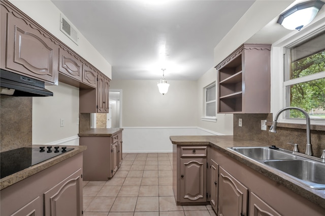 kitchen featuring kitchen peninsula, black electric stovetop, tasteful backsplash, sink, and light tile patterned floors