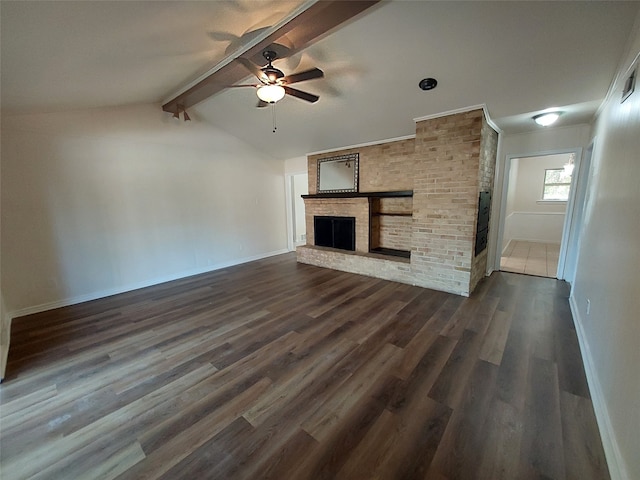 unfurnished living room with lofted ceiling with beams, ceiling fan, dark hardwood / wood-style flooring, and a brick fireplace