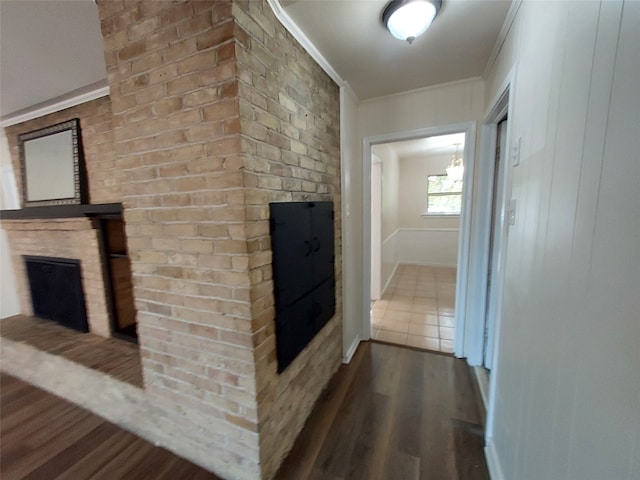 corridor with wood-type flooring and crown molding