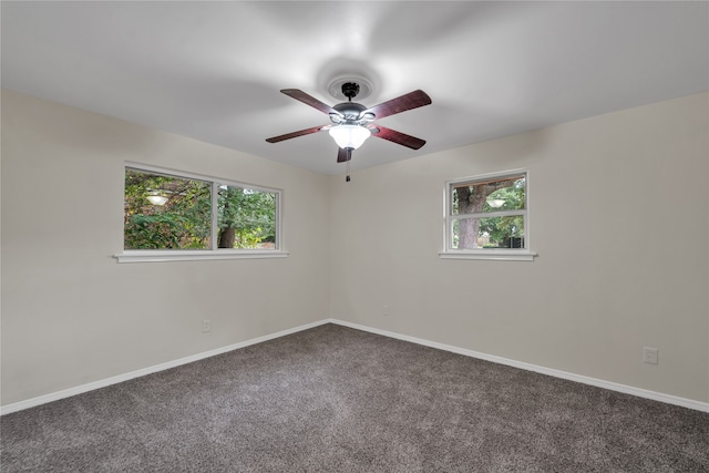 carpeted spare room with ceiling fan and plenty of natural light