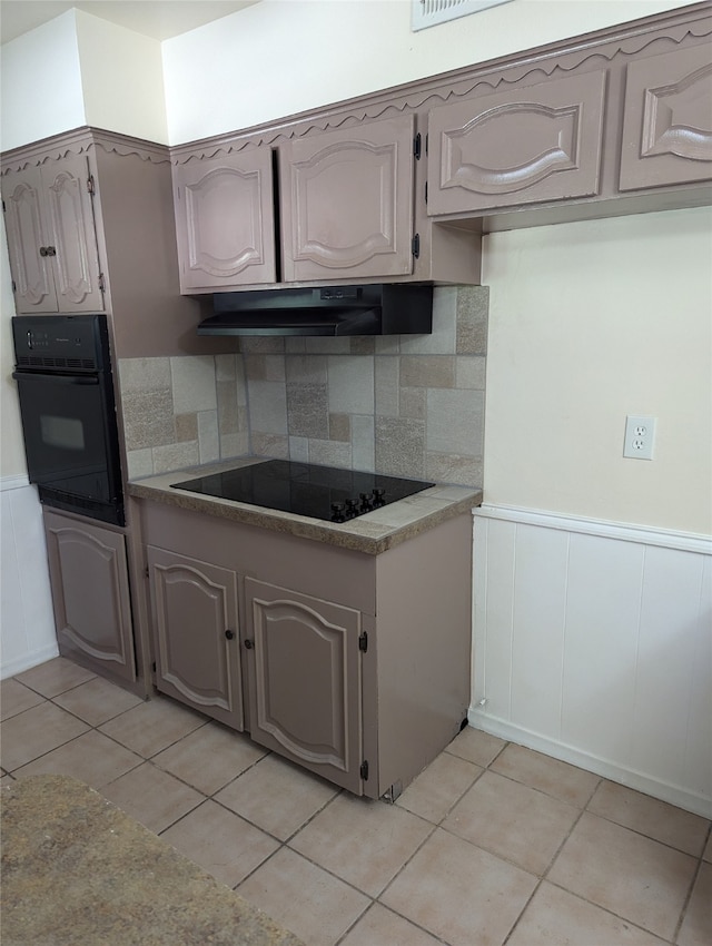 kitchen with backsplash, light tile patterned flooring, and black appliances