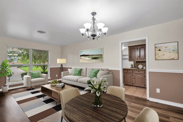 living room featuring a chandelier and light hardwood / wood-style flooring