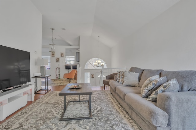 living room with hardwood / wood-style flooring, high vaulted ceiling, and a notable chandelier