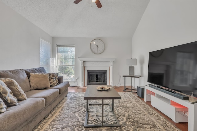 living room with ceiling fan, a textured ceiling, lofted ceiling, and hardwood / wood-style floors