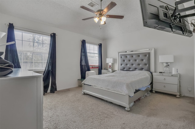 bedroom featuring light carpet, ceiling fan, and a textured ceiling