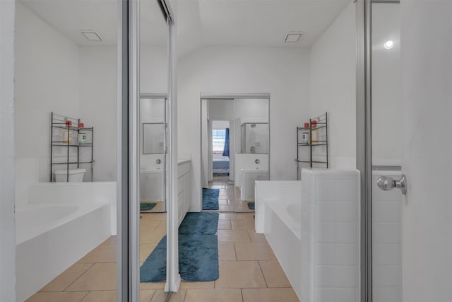 bathroom featuring shower with separate bathtub, lofted ceiling, and tile patterned floors