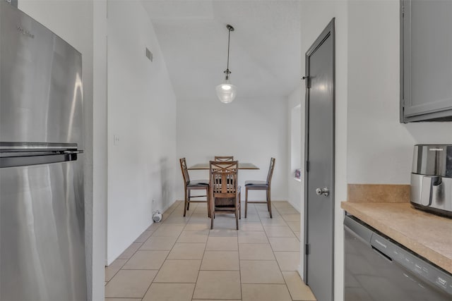 tiled dining space featuring vaulted ceiling