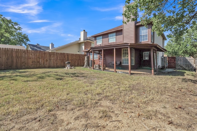 rear view of property featuring a patio and a yard