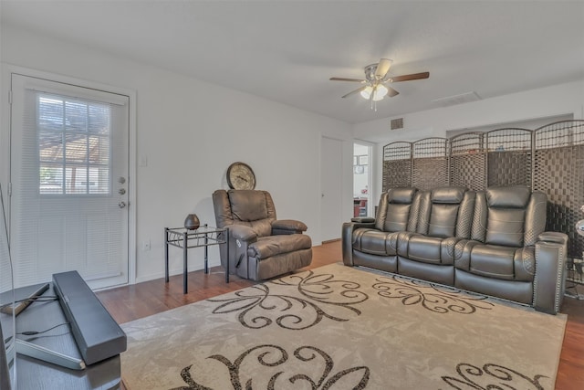 cinema room featuring ceiling fan and hardwood / wood-style flooring