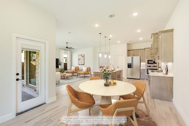 dining area with light wood-type flooring, sink, and ceiling fan