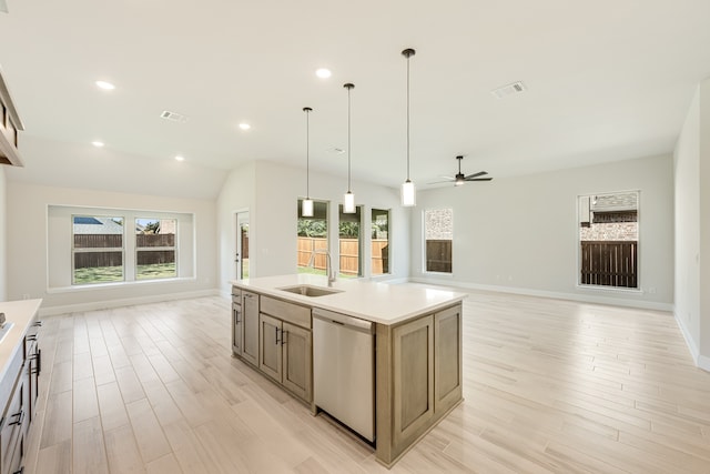 kitchen with dishwasher, plenty of natural light, hanging light fixtures, and an island with sink