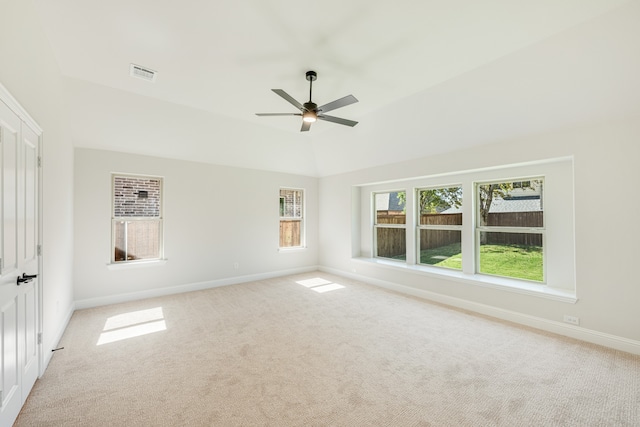 empty room with plenty of natural light, light carpet, and vaulted ceiling