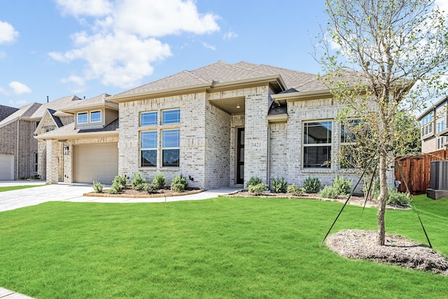 view of front of property with a front lawn, central air condition unit, and a garage