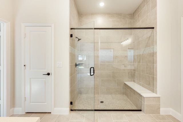 bathroom featuring a shower with shower door and tile patterned flooring