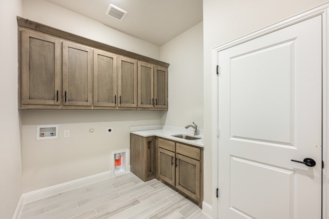 laundry room with electric dryer hookup, cabinets, sink, hookup for a gas dryer, and hookup for a washing machine