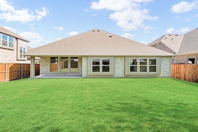 rear view of house featuring a lawn and a patio area