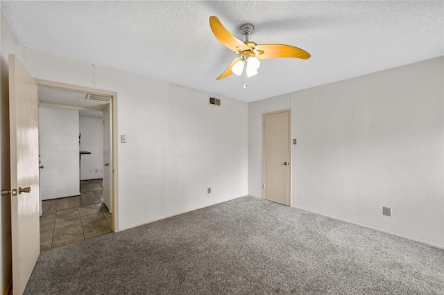 carpeted empty room featuring ceiling fan and a textured ceiling