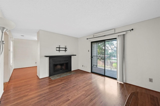 unfurnished living room featuring wood-type flooring and a textured ceiling