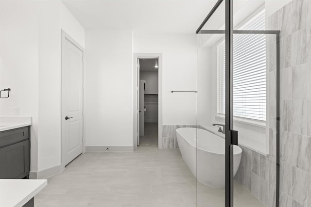 bathroom featuring vanity, tile patterned floors, independent shower and bath, and tile walls