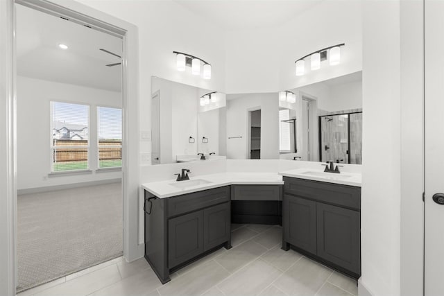 bathroom with tile patterned flooring, vanity, and walk in shower