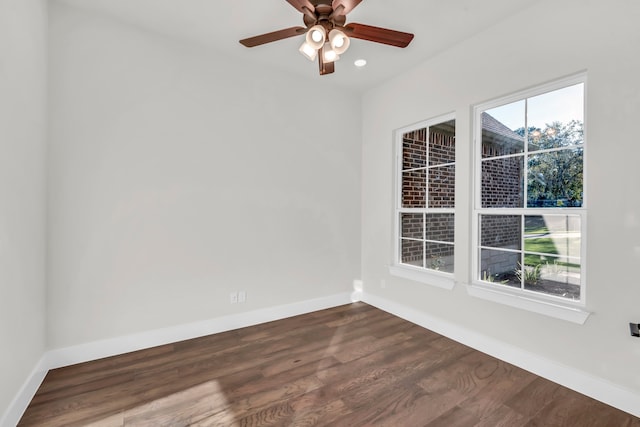 spare room featuring dark wood-type flooring and ceiling fan