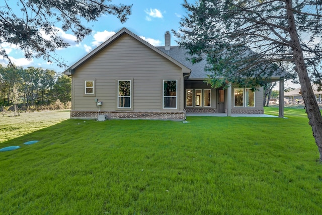 rear view of house featuring a yard