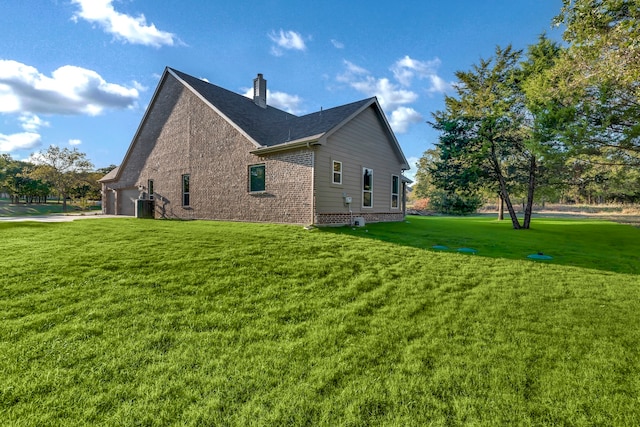 view of home's exterior with a lawn and central AC