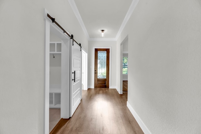 doorway featuring a barn door, hardwood / wood-style flooring, and crown molding