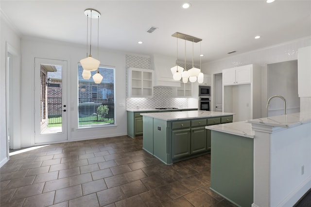 kitchen featuring tasteful backsplash, stainless steel appliances, white cabinets, a kitchen island, and dark tile patterned flooring