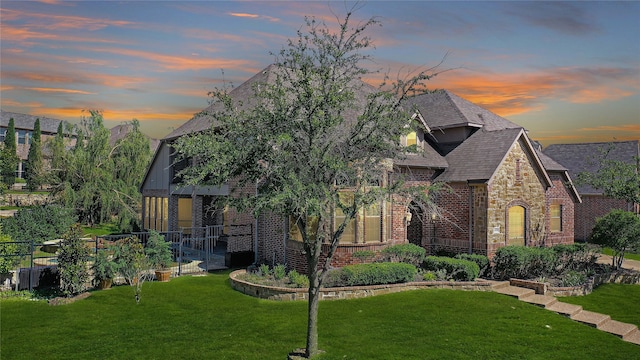 tudor-style house featuring a lawn