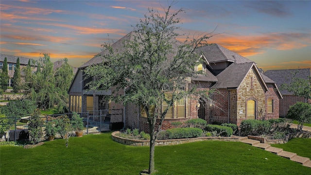 english style home with a lawn