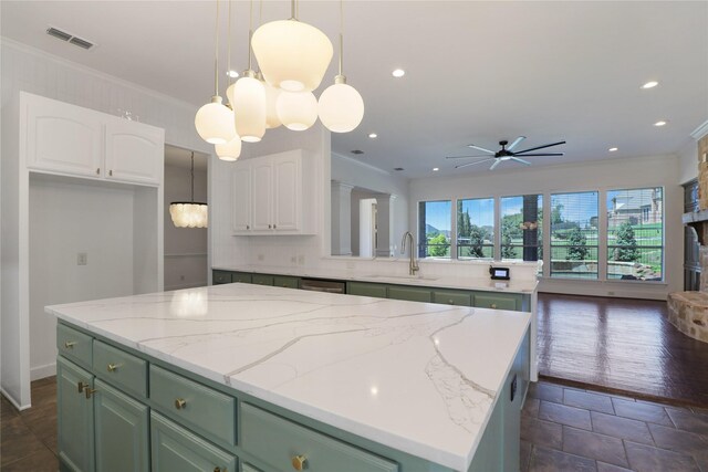 kitchen featuring crown molding, a center island, dark hardwood / wood-style flooring, decorative light fixtures, and sink