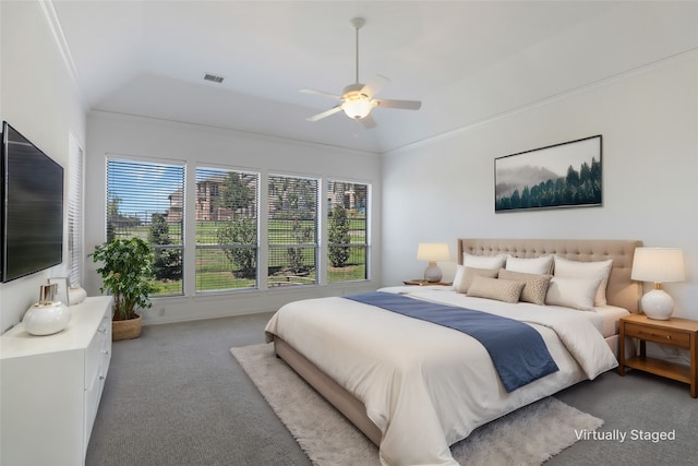 carpeted bedroom featuring vaulted ceiling, crown molding, and ceiling fan