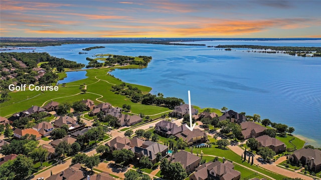 aerial view at dusk featuring a water view