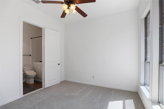 unfurnished bedroom with connected bathroom, carpet floors, and ceiling fan