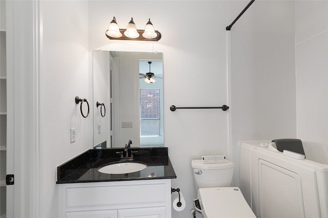 bathroom with washer / clothes dryer, toilet, vanity, and ceiling fan