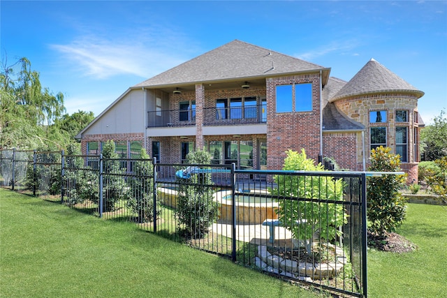 back of house featuring a balcony, a lawn, and a fenced in pool