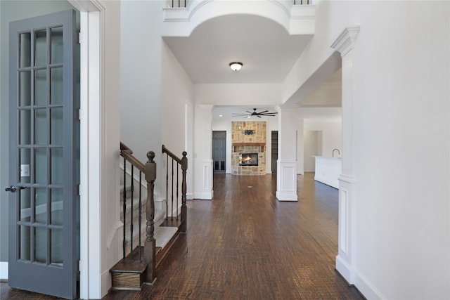 hall featuring dark hardwood / wood-style floors and ornate columns