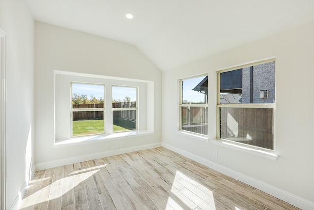 unfurnished room with vaulted ceiling and light hardwood / wood-style flooring