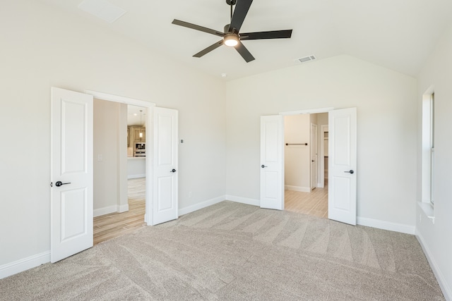 unfurnished bedroom featuring ceiling fan, light carpet, and lofted ceiling