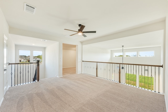 carpeted spare room featuring ceiling fan