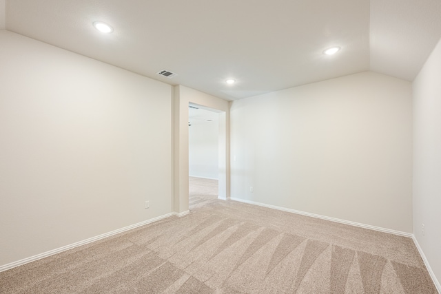 empty room with carpet flooring and vaulted ceiling