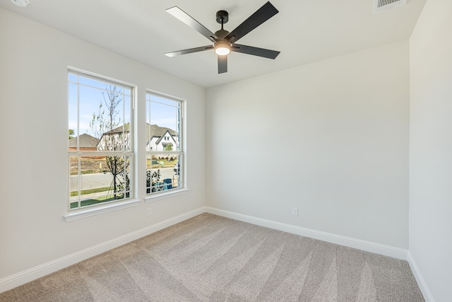 carpeted spare room featuring ceiling fan