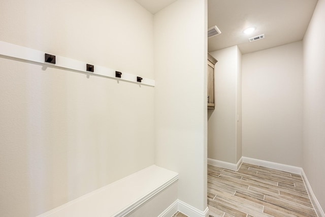 mudroom with wood tiled floor, baseboards, and visible vents