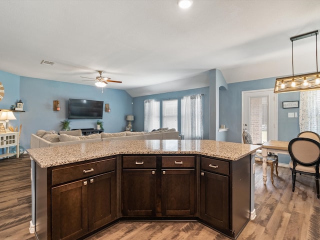 kitchen featuring hardwood / wood-style floors, decorative light fixtures, a center island, and dark brown cabinetry